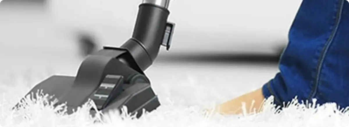 Close-up of a professional vacuuming a white carpet in Linthicum Heights.
